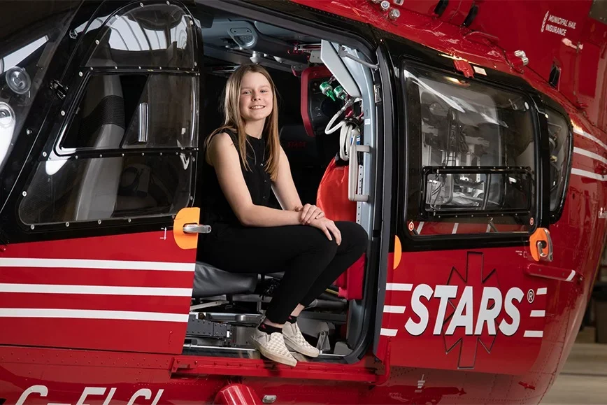 Photo of Jorja Strauss sitting on the edge of the STARS helicopter